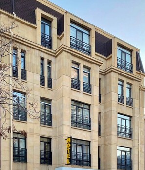 A multi-story hotel with a beige facade, large windows, and balconies. - Alvera Hotel Baku (Baku)