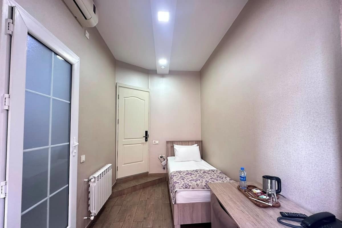 Habitación individual estándar, vista al jardín | Escritorio, tabla de planchar con plancha y ropa de cama 