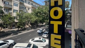 Placa de hotel com vista clara para a rua e carros estacionados.
