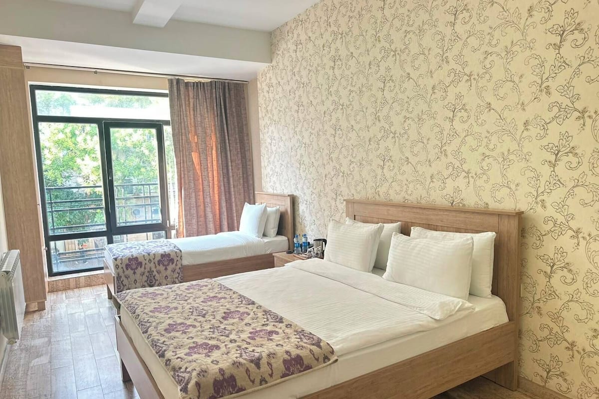 Habitación triple estándar | Escritorio, tabla de planchar con plancha y ropa de cama 