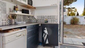 Una cocina compacta equipada con microondas, un lavaplatos y lavavajillas Bosch.