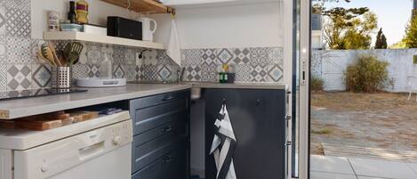Una cocina compacta equipada con microondas, un lavaplatos y lavavajillas Bosch.