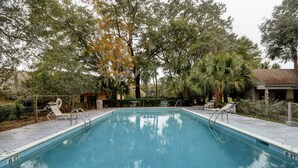 A rectangular swimming pool with a 8 ft depth marker, surrounded by trees and a small building. - Sunset Rentals | Queens Grant 616 | Dog Friendly (Hilton Head Island)