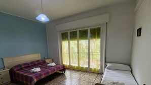Ein Schlafzimmer mit einem Bett, einem Nachttisch, einem Fenster mit Blick und einer Deckenleuchte.