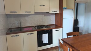 Eine Küche mit Spüle, Herd, Backofen und Schränken.
