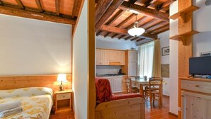 A bedroom with a bed, bedside table, and lamp. - To complete (Castel del Piano)
