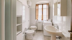 A bathroom with a toilet, bidet, sink, and a cabinet. - Casa Maria Amiata: A Cozy House Amid Nature and Comfort (San Lorenzo)