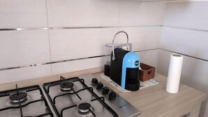 A kitchen with a gas stove, a coffee maker, and a roll of paper towels on the counter. - Everything is just a bike ride away! 10 minutes to the beach with free (Grosseto)