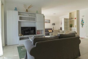 A living room with a TV, sofa, and shelving unit. - To complete (Grosseto)