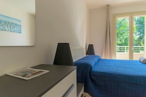 A hotel room with a bed, a desk with a chair, a window with curtains, and a painting on the wall. - To complete (Grosseto)