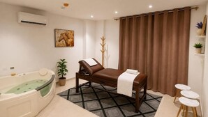 Un baño moderno con bañera, mesa de masaje, perchero y planta en maceta.