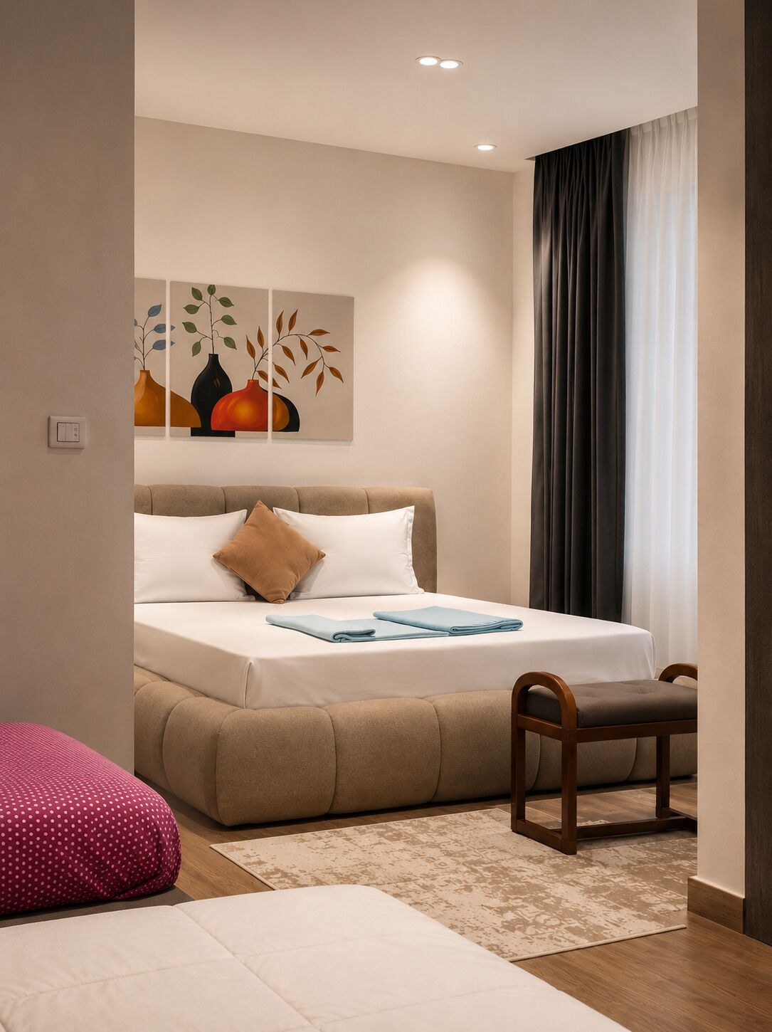 A modern bedroom with a bed, a chair, a pillow, a rug, and a painting on the wall.