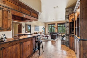 A spacious kitchen with a large island, wooden cabinets, and a stone accent wall.