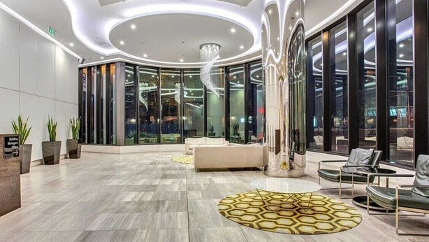 A modern lobby with a circular ceiling design, seating areas, and a glass entrance. - Yarra Luxe on Chapel Street by SAGA stays (South Yarra)