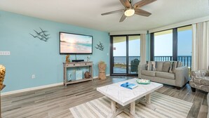 A living room with a flat-screen TV, a wooden coffee table, and a sofa. - Phoenix Vii 7505 3 Bedroom Condo (Orange Beach)