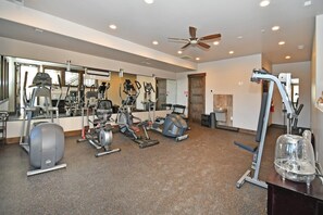 A gym with various exercise equipment, a ceiling fan, and a large mirror. - Pool Hot Tub And Luxury Living At Blackstone 3k 2 Bedroom Condo (Park City)