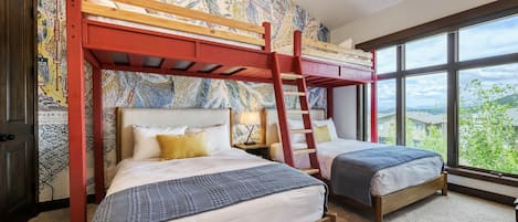 Een kamer met stapelbedden, een groot raam en een muur met een wereldkaart.