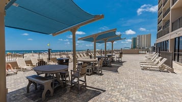 A rooftop patio with outdoor seating and a view of the ocean.