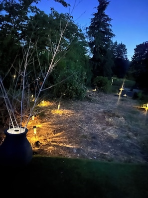 A garden area with pathways and trees, illuminated by ground lights. - Villa Papillon Clermont-Ferrand, 3-star, for 2 to 6 people, Clermont-Ferrand (Nohanent)