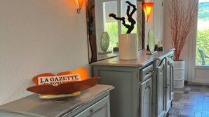 A well-lit hallway with a decorative mirror, a vintage-style dresser, and a potted plant. - Villa Papillon Clermont-Ferrand, 3-star, for 2 to 6 people, Clermont-Ferrand (Nohanent)