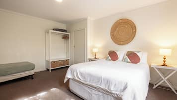 A bedroom with a bed, bedside tables, a wardrobe, and a wall-mounted circular decoration.