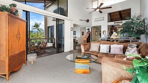 A spacious living area with a large sofa, a glass coffee table, and a wooden cabinet. - Kksr#1301 Direct Oceanfront, Best North Corner Top Floor Location (KAILUA KONA)