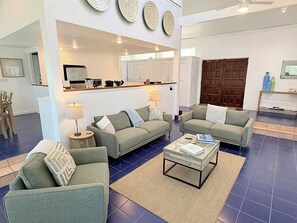 Ein Wohnzimmer mit zwei Sofas, einem Couchtisch und einer Küche im Hintergrund.