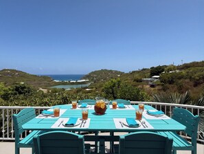 A table set for four with a pitcher and glasses of iced tea, overlooking a coastal landscape. - Private 3 Bedroom Villa with Pool, Central A/C & Ocean Views in Chocolate Hole, St. John, USVI (St John)