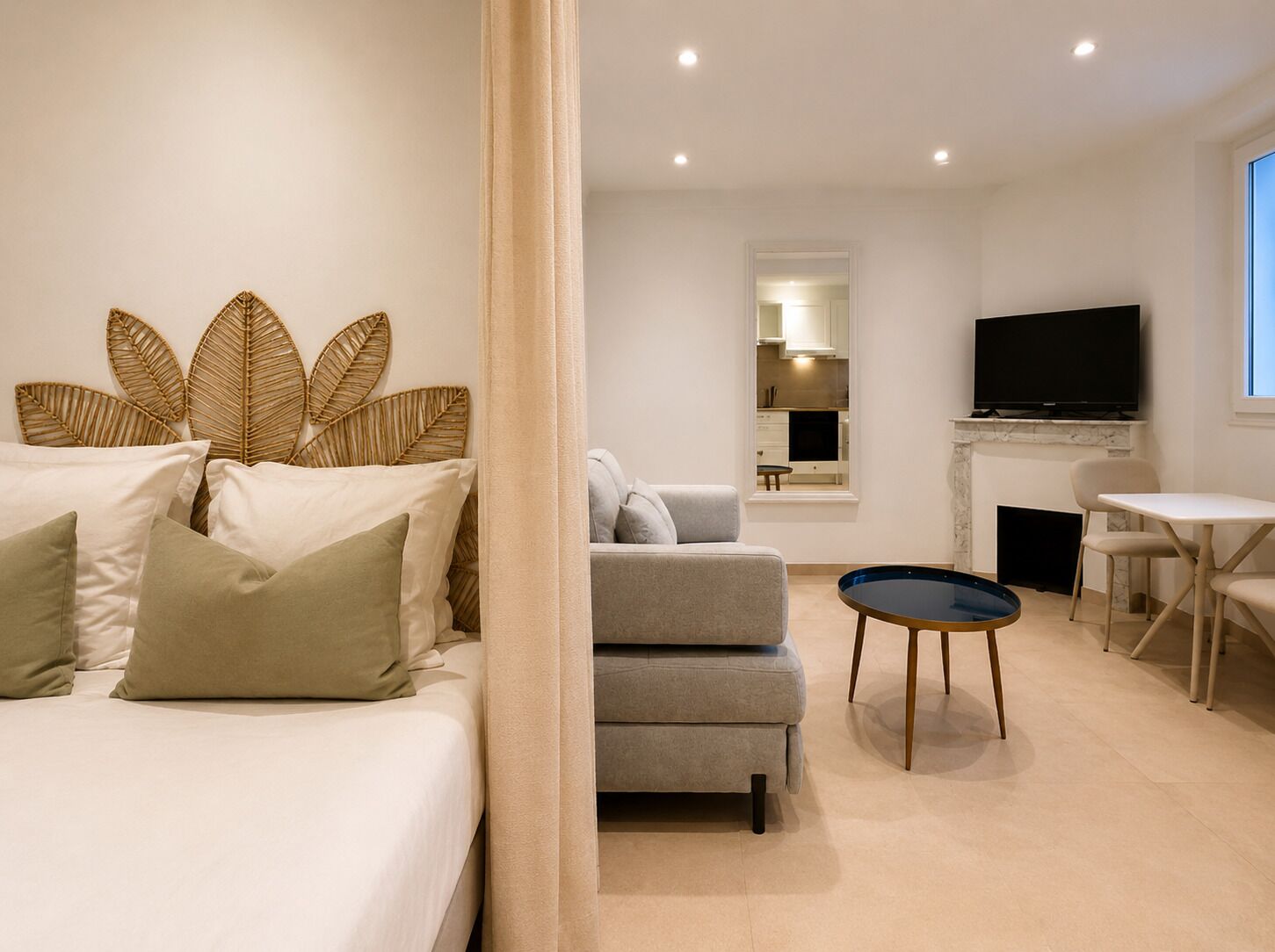 A modern living room with a sofa, a television, and a dining area.