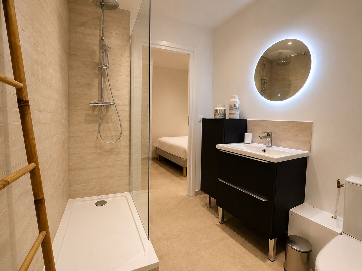 Une salle de bain moderne avec une douche à parois de verre, un lavabo blanc et des toilettes.