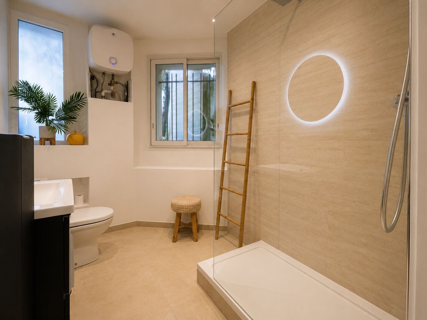 A modern bathroom with a toilet, sink, bathtub, and a window.