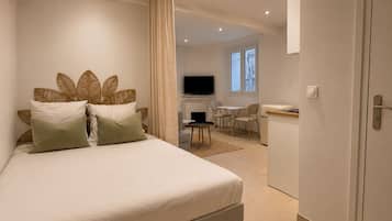 Une chambre à coucher avec un lit, une télévision, un bureau et une chaise.