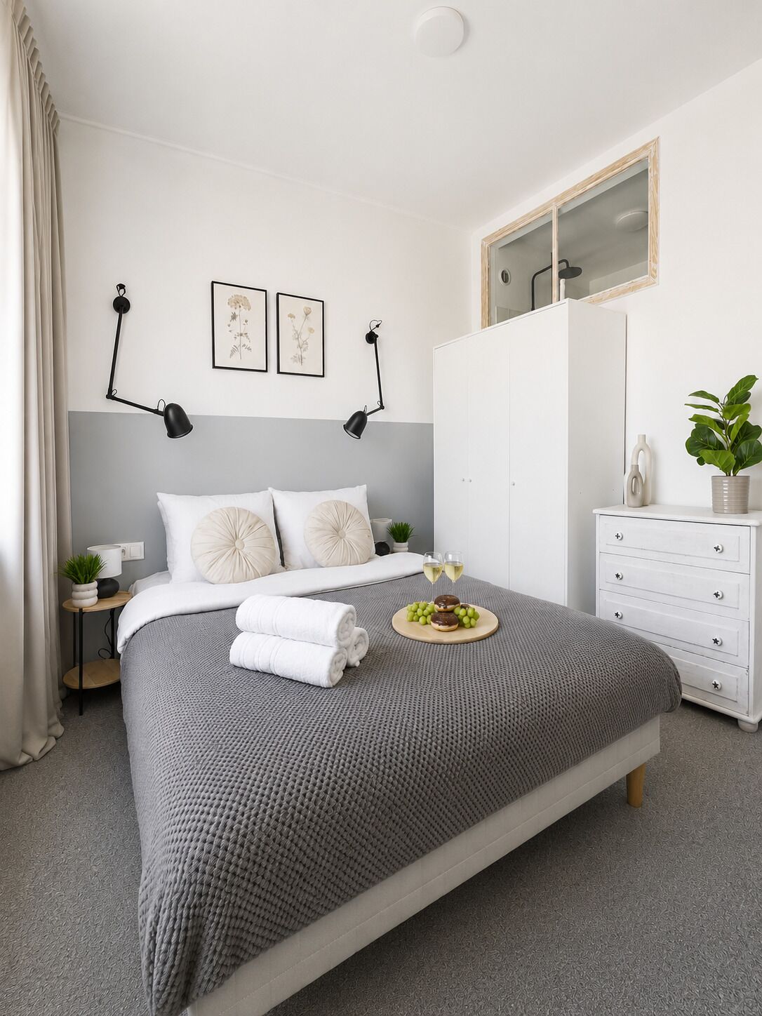 A neatly arranged bedroom with a bed, bedside tables, a dresser, and a mirror.