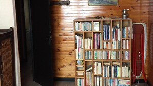 A room with wooden walls and a bookshelf filled with books. - 100 M² DUPLEX "SPECIAL OFFER" IN THE HEART OF LES CARROZ—Sleeps 9, 3 bedrooms, 2 bathrooms (Arâche -La-Frasse)
