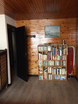 A room with wooden walls and a bookshelf filled with books. - 100 M² DUPLEX "SPECIAL OFFER" IN THE HEART OF LES CARROZ—Sleeps 9, 3 bedrooms, 2 bathrooms (Arâche -La-Frasse)