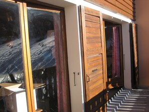 A wooden staircase leading to a room with a sliding door. - 100 M² DUPLEX "SPECIAL OFFER" IN THE HEART OF LES CARROZ—Sleeps 9, 3 bedrooms, 2 bathrooms (Arâche -La-Frasse)