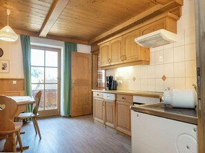 Una cocina con armarios de madera, cafetera y refrigerador blanco.