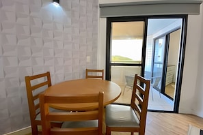 Un comedor con una mesa redonda de madera y cuatro sillas.