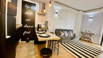 Uma cozinha moderna com área de refeições, um sofá e um tapete decorativo.