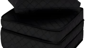 Un otomán negro acolchado con un cojín a juego.