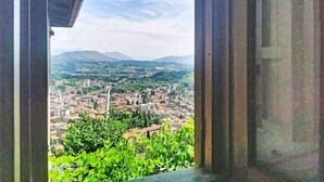 Blick durch eine offene Tür auf eine Stadtlandschaft mit Bergen im Hintergrund.