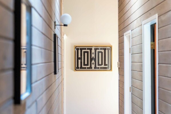 A hallway with a wall-mounted sign that reads 'HOTEL' in a decorative font.
