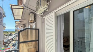 Un balcon avec une grille en métal, des unités de climatisation et une vue sur la rue.
