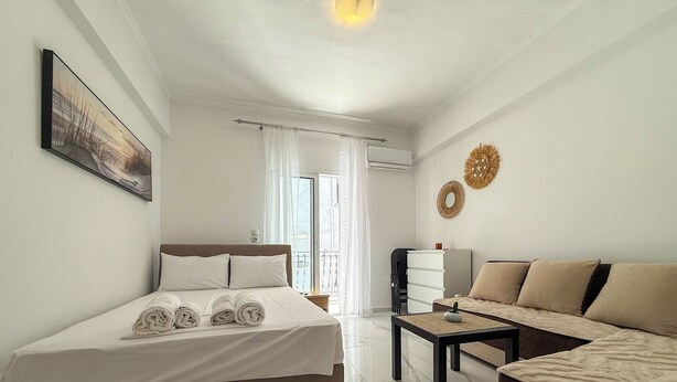 Une chambre d’hôtel avec un lit, un canapé, une petite table et un balcon avec vue.
