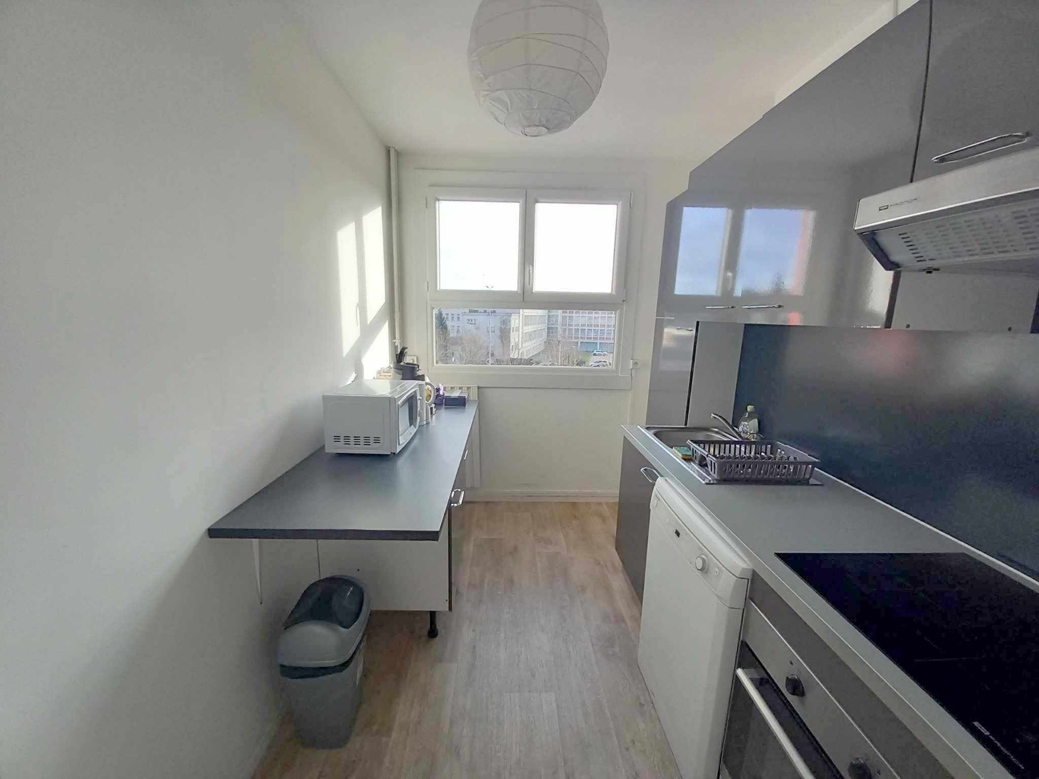 A compact kitchen with a microwave, stove, and dishwasher.