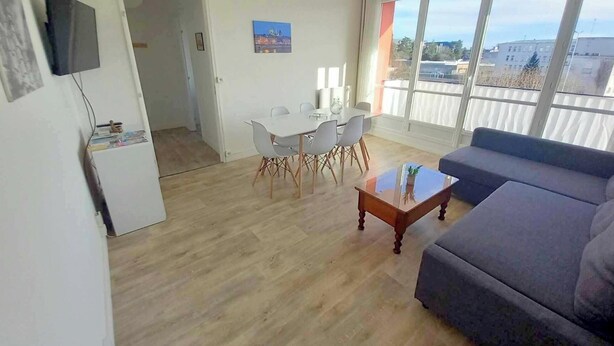 Ein Wohnzimmer mit einer Couch, einem Couchtisch und einem Essbereich mit Stühlen und einem Tisch.