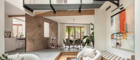 Ein modernes Interieur mit einem Wohnbereich im Loft-Stil, einem Essbereich und einer Küche.