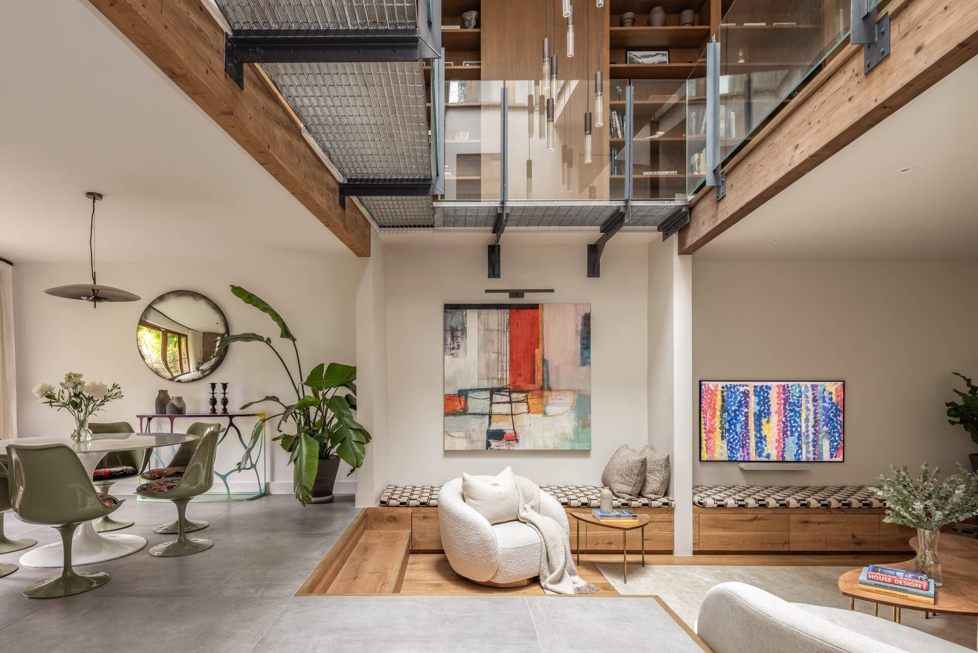 Un vaste espace de vie doté d’un haut plafond, d’une mezzanine et d’un mobilier moderne.