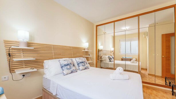 A hotel room with a bed, bedside tables, a mirror, and a wardrobe. - Los Boliches Rooftop Retreat • 1BR Sleeps 3 - Pass the Keys (Fuengirola)