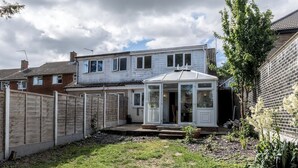 A residential property with a fenced backyard, a conservatory, and a brick wall. - 4-Bedroom Home | Sleeps 10 | Parking | Garden - Pass the Keys (Basildon)